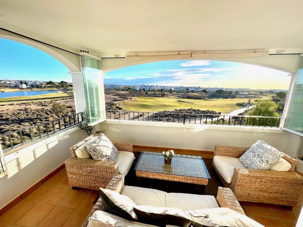 un salon avec deux canapés et une grande fenêtre dans l'établissement Hacienda Riquelme Golf Resort Fantastic Apartment, à Sucina