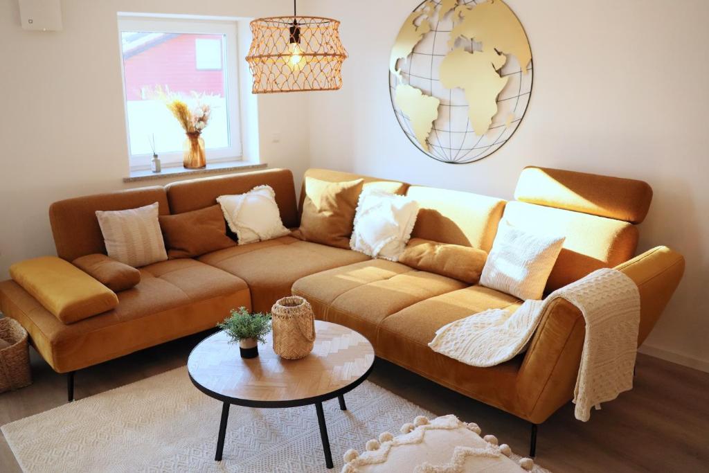 a living room with a brown couch and a table at SONNENglück in Altusried