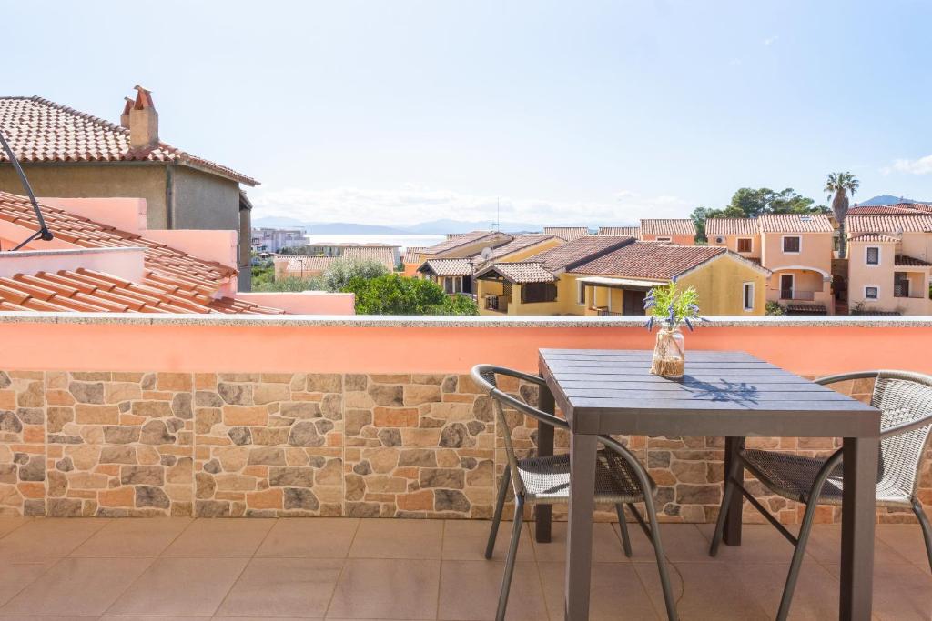 een tafel en stoelen op het balkon van een gebouw bij Camera Ponente - vista mare, spiaggia a 300m in Golfo Aranci