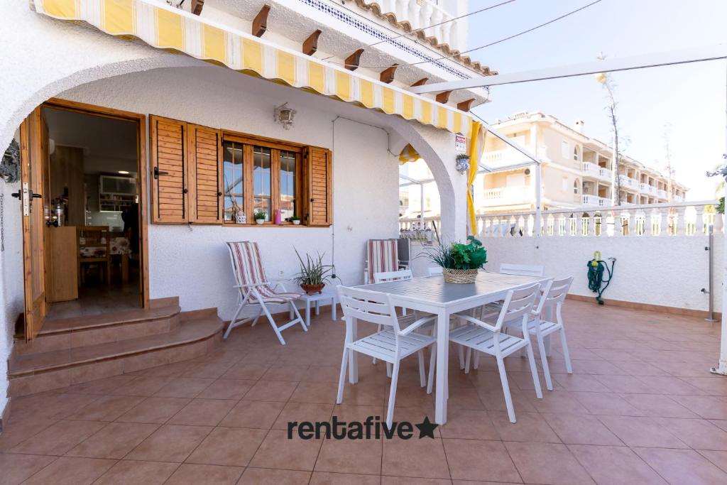 un tavolo bianco e sedie su un patio di rentafive 8pax Terraza 1min playa a Santa Pola