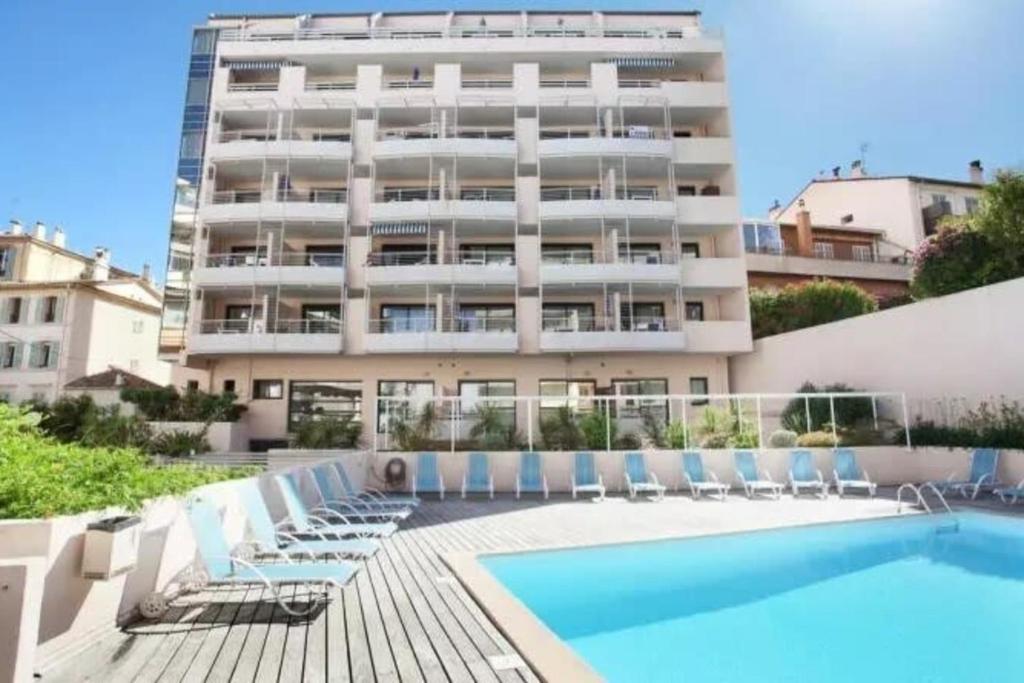 un grand immeuble avec piscine et chaises longues dans l'établissement LES FELIBRIGES - 2-room flat - Ideal for congresses in Cannes, à Cannes