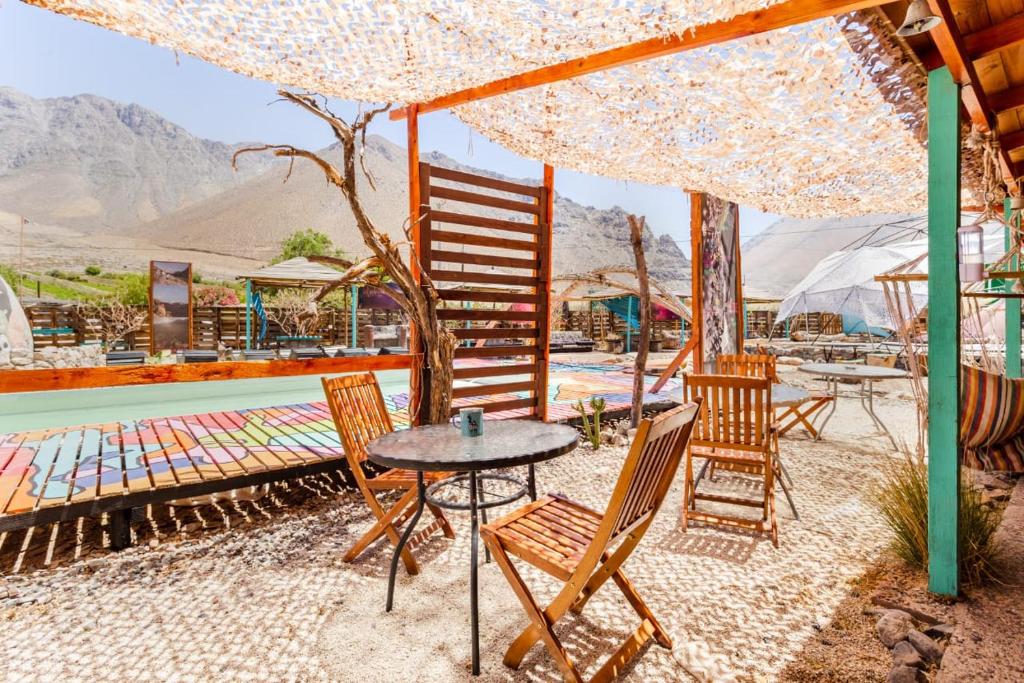 a patio with a table and chairs and a pool at Hostal Cosmo Elqui in Rivadavia