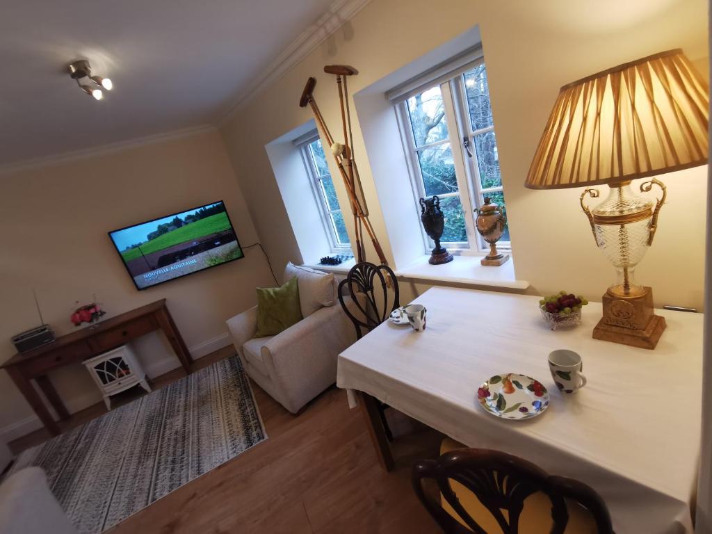 a living room with a table with a lamp and a couch at Castle Retreats Nest & Crown in Torquay