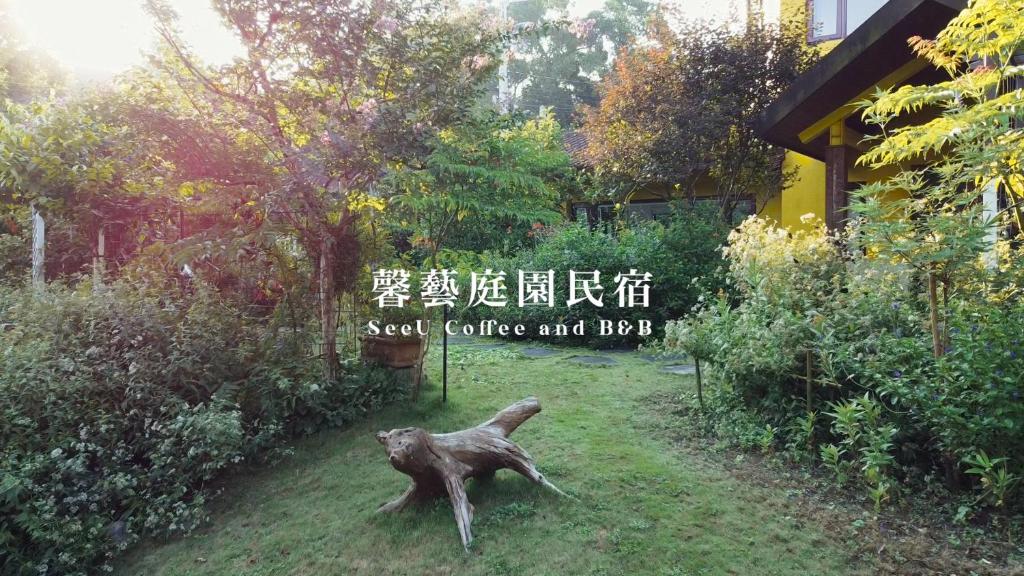 a statue of a cat standing in a garden at SeeU Coffee and B&B in Xihu