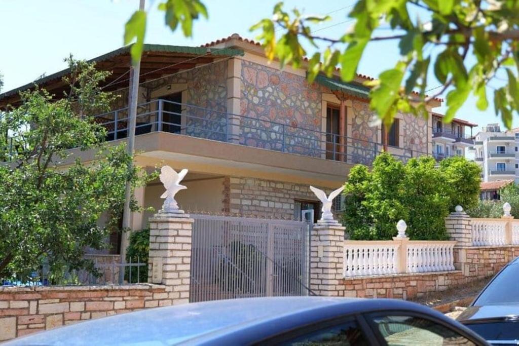 uma casa com uma cerca e um carro à frente dela em Villa Korado em Saranda