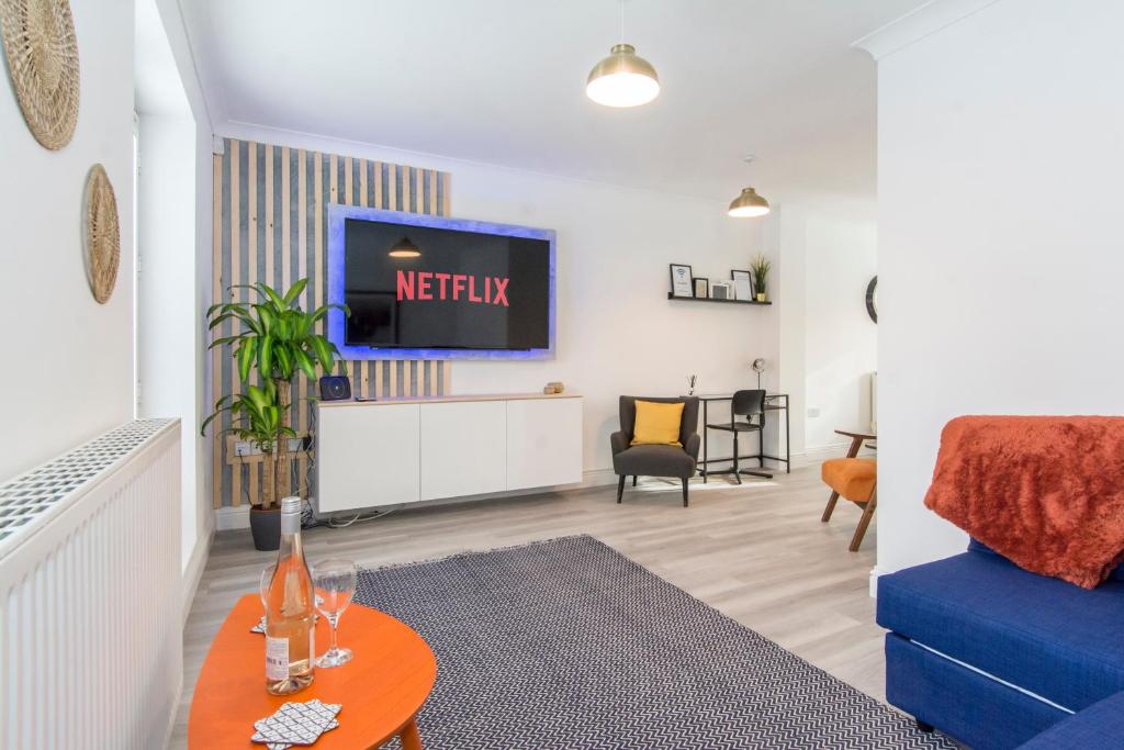 a living room with a tv and a blue couch at Host & Stay - Davies Close in Market Harborough