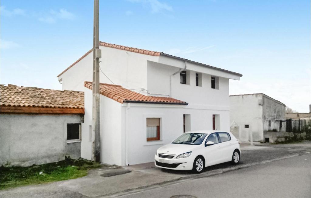 un coche blanco estacionado frente a una casa blanca en Cozy Apartment In Santander With Kitchen, en Santander