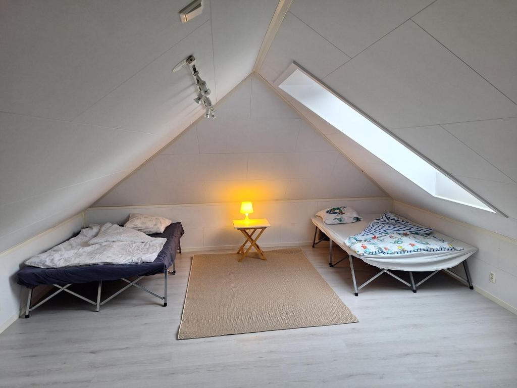 a attic bedroom with two beds and a table at Unik, stor leilighet i hjertet av Sandnes in Sandnes