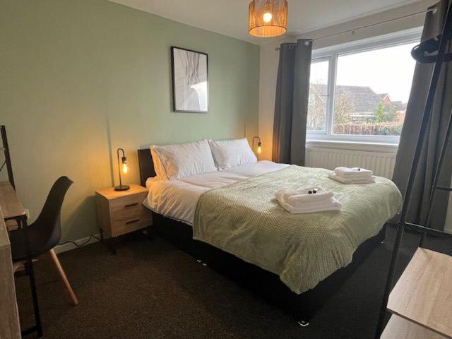 a bedroom with a bed with two towels on it at Harmony House - 4 Doubles, Free Wi-fi, Parking in Walsall