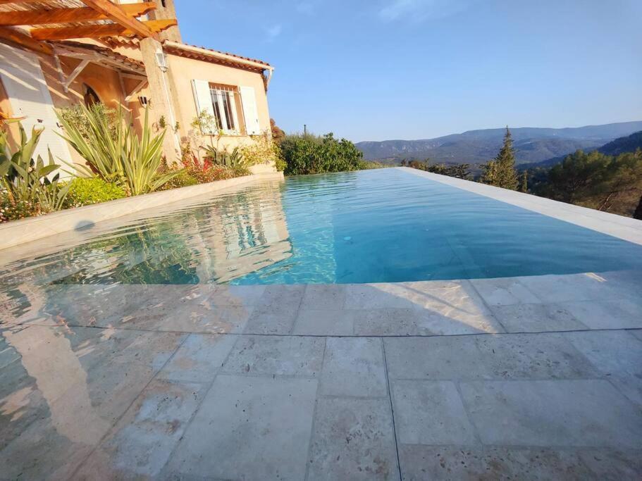 una piscina frente a una casa en Superbe villa avec piscine, en LʼEscarène