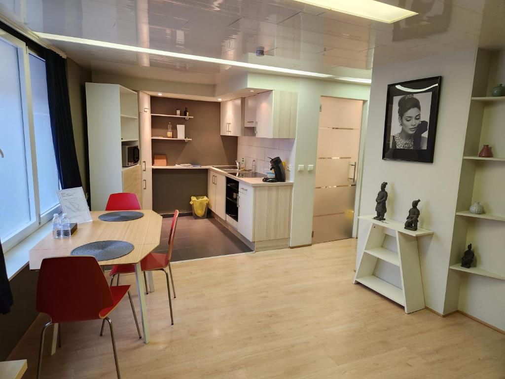 una cucina e una sala da pranzo con tavolo e sedie di Studio Astrid a Mechelen