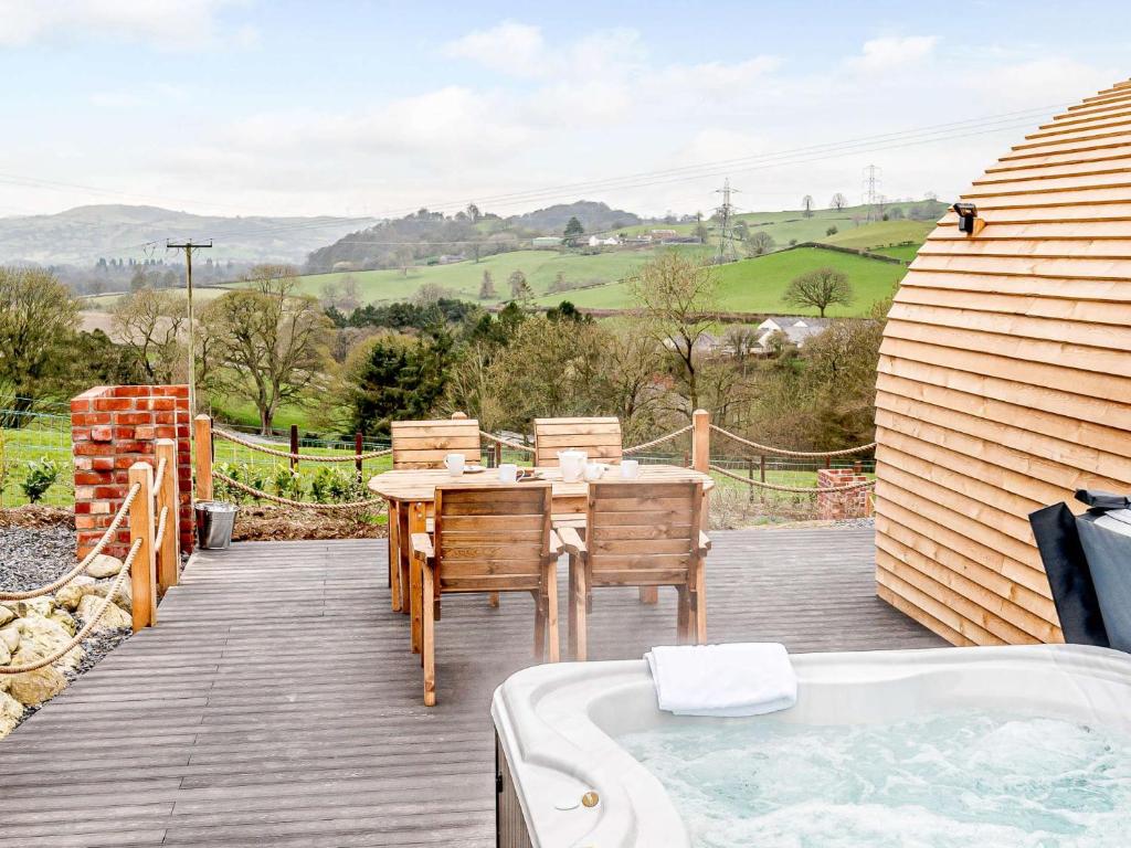 a wooden deck with a table and a bath tub at 1 Bed in Corwen 80321 in Gwyddelwern