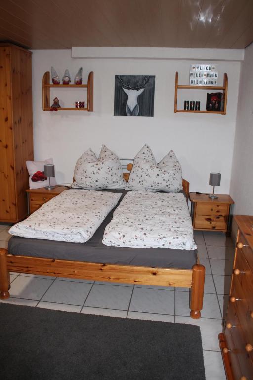 a bedroom with a wooden bed with pillows at Schwarzwaldstube 2 Zimmer für Gäste in Vörstetten in Vörstetten