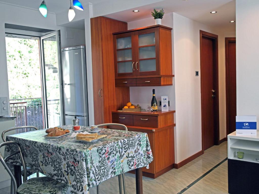 une cuisine avec une table et des chaises et une cuisine avec un comptoir dans l'établissement Casa Clo' by Holiday World, à Gênes