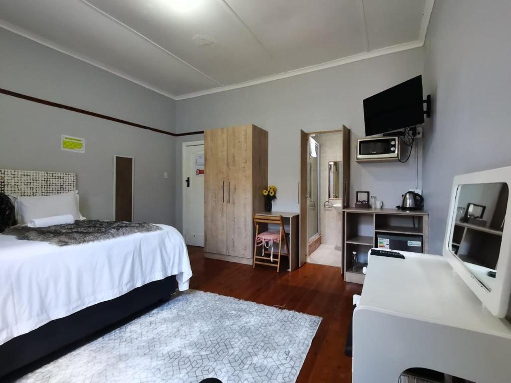 um quarto com uma cama, uma televisão e um sofá em PLANES em Kokstad