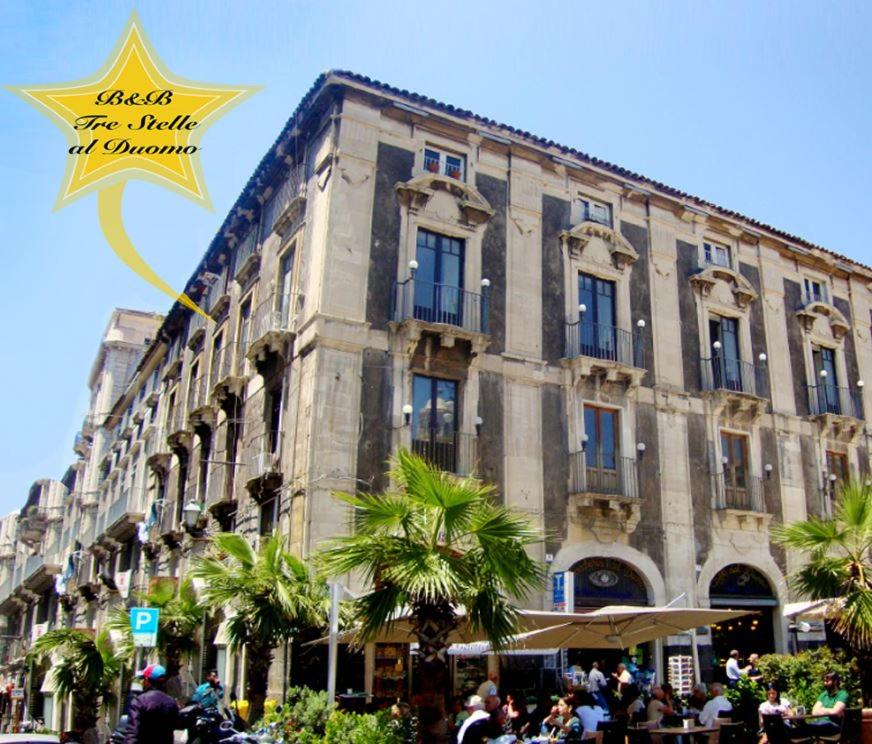 un grande edificio con un cartello con la stella di Tre Stelle al Duomo a Catania