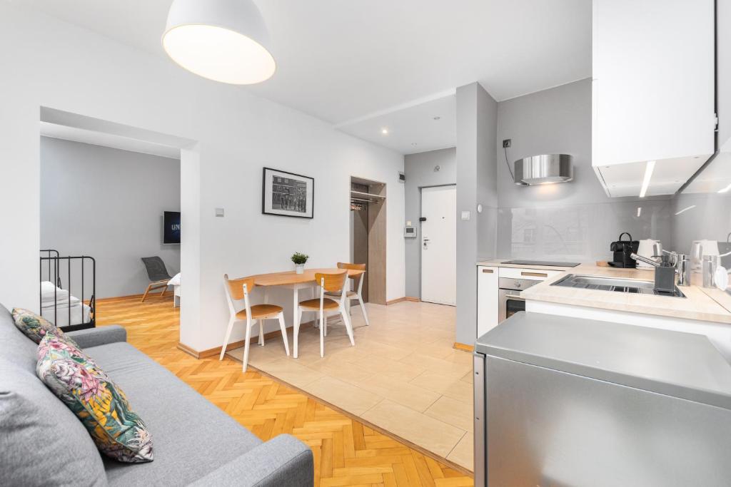 a kitchen and living room with a couch and a table at Apartament Wspólna by Your Freedom in Warsaw