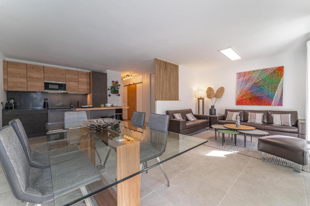 une salle à manger et un salon avec une table en verre dans l'établissement Les Bergeronnettes - Piscine partagée proche plage, à Gujan-Mestras