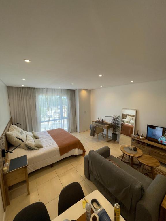 um quarto com uma cama e uma sala de estar em WYNDHAM DEPARTAMENTOS Nordelta Tigre Buenos Aires em Tigre