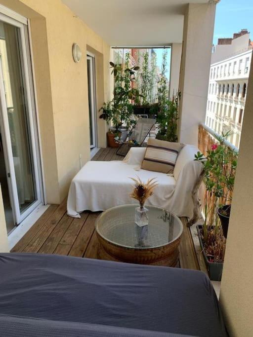 Cette chambre dispose de deux lits et d'une table sur un balcon. dans l'établissement Gounod - Spacieux T2 - idéal pour couple, à Nice