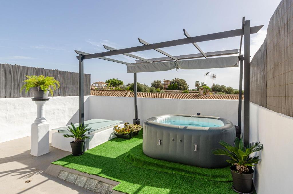 a hot tub on a patio with a pergola at YourHouse Es Pla Cycling House in Maria de la Salut