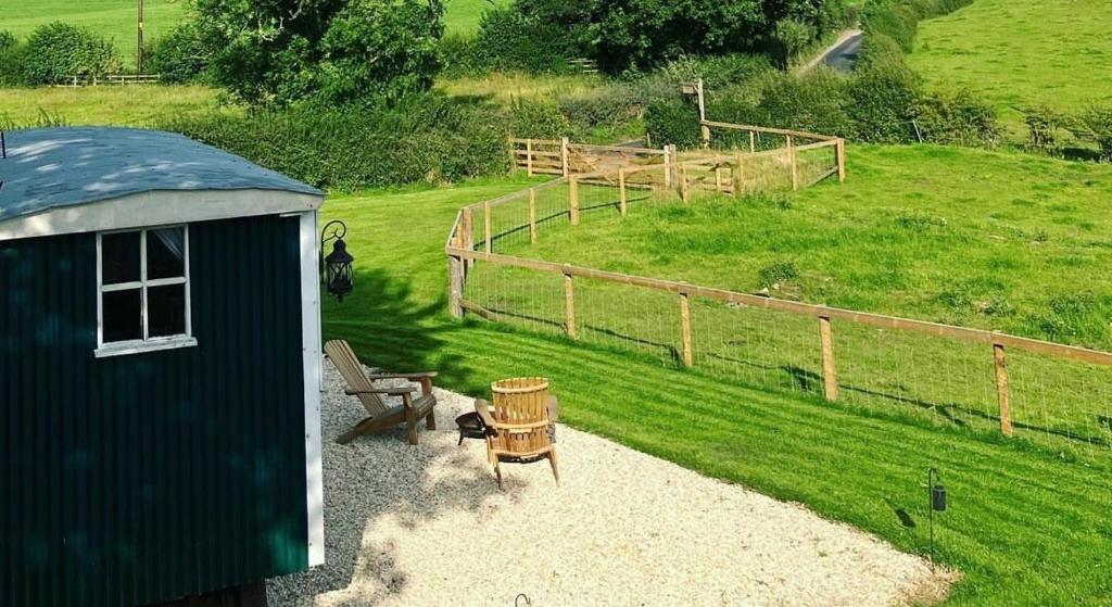 a small shed with a bench and a fence at Peggy’s Hut in Astbury