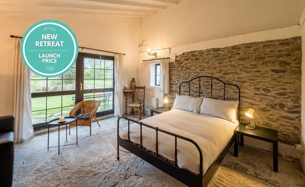 une chambre avec un lit et un mur de briques dans l'établissement Ventry Farm - The Parlour Cottage by Trident Holiday Homes, à Ventry