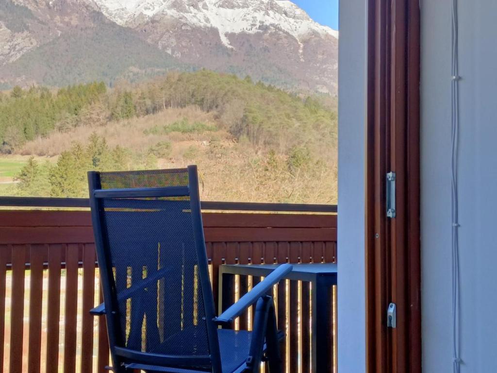 a blue chair sitting on a balcony looking out a window at Appartamento Monte Irone in Ponte delle Arche