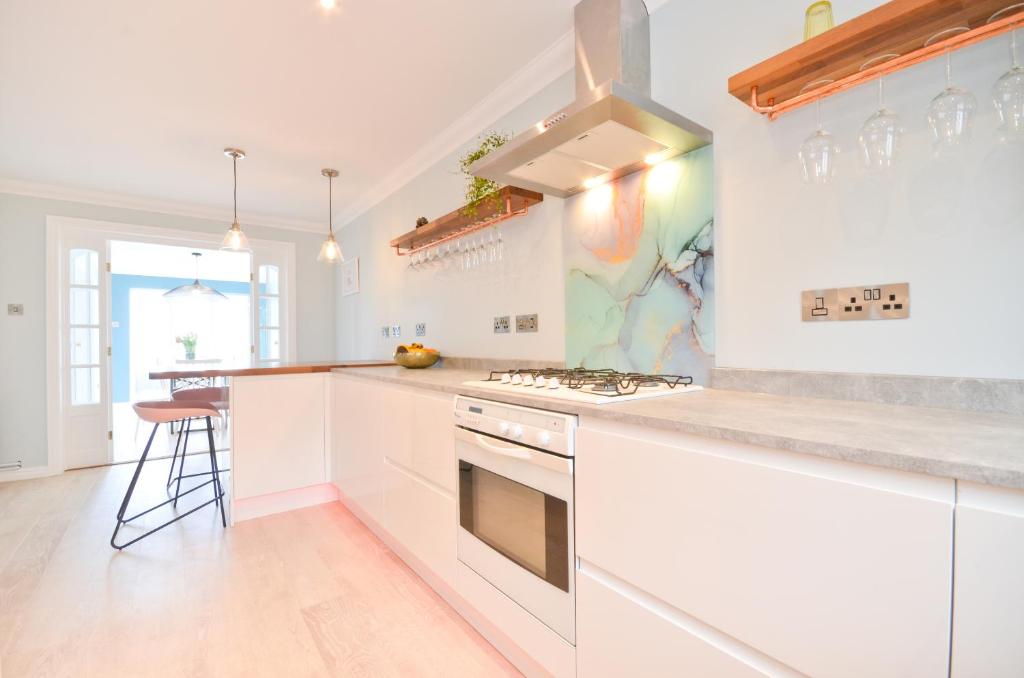 a kitchen with white cabinets and a stove top oven at Princes Esplanade in Cowes