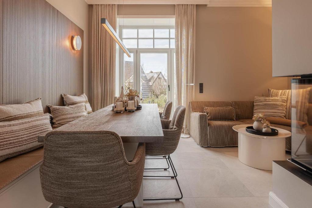 a kitchen and living room with a table and chairs at Ocean-Breeze-2 in Wenningstedt