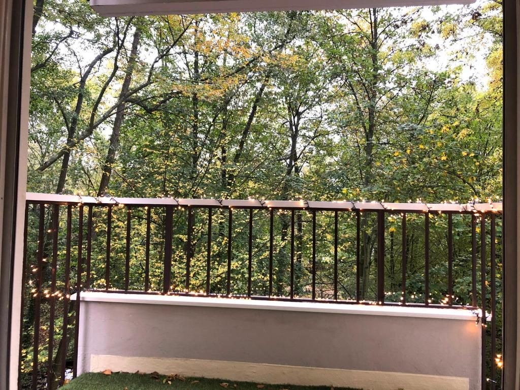 a balcony with a black fence and trees at Appartement Cosy Luxury with Lake in Brunoy