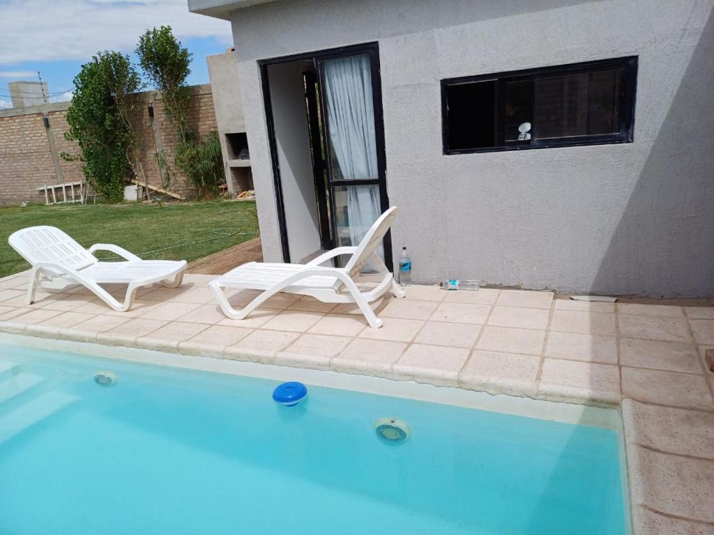 2 sillas sentadas junto a una piscina en Alojamiento San Juan, en Trinidad