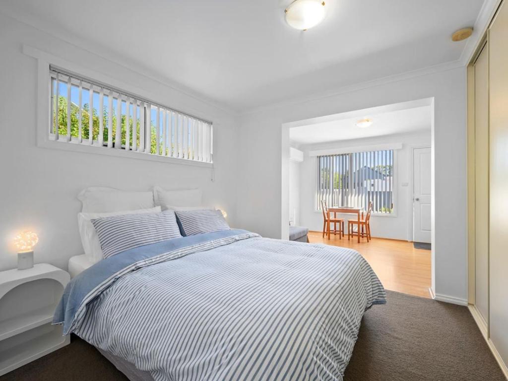 a white bedroom with a bed and a table at Kalisti Suites - Fira Suite in Port Sorell