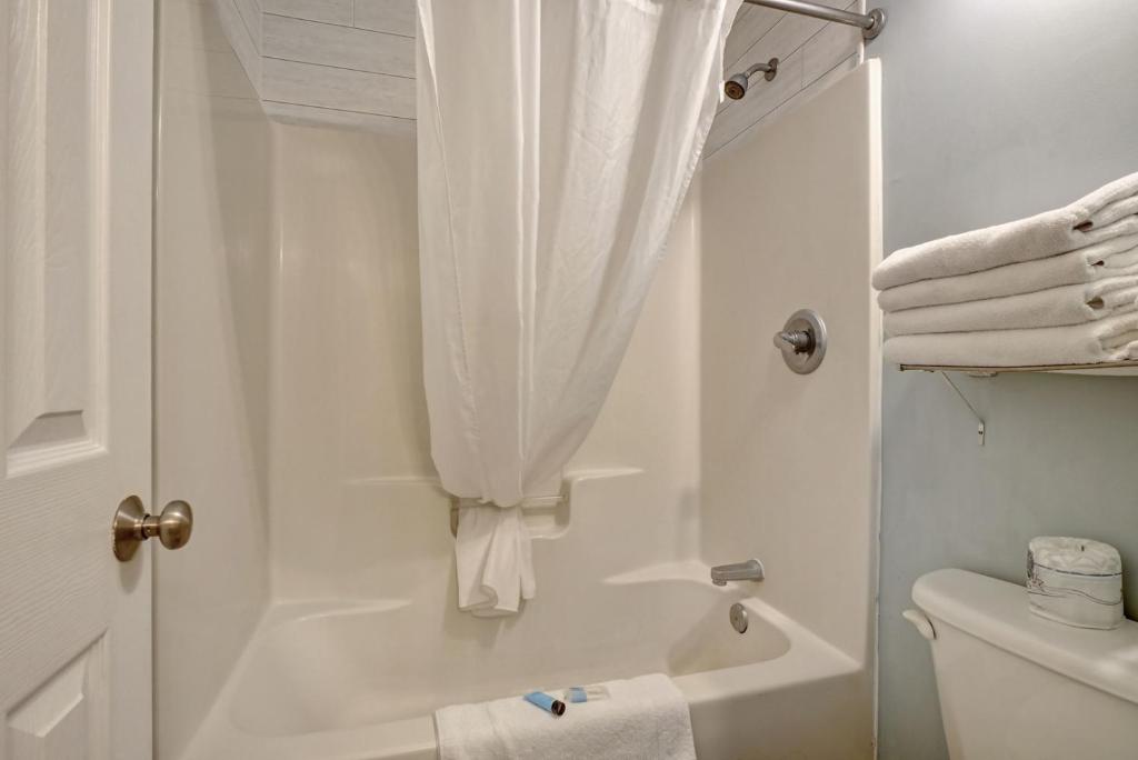 y baño blanco con ducha y aseo. en Unit 102D at Tiffany's, en Surf City