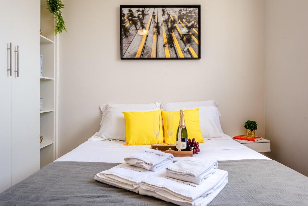 Una cama con toallas y una botella de vino. en Allianz Parque - Apartamento com Vista Incrível e Academia, en São Paulo