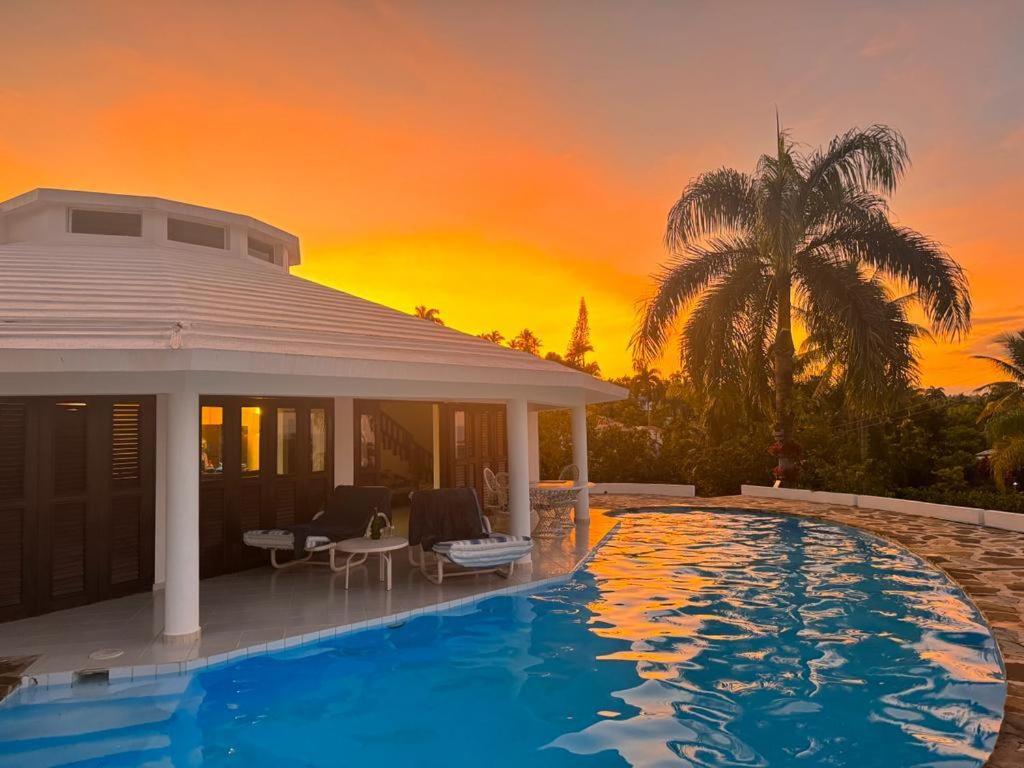 a villa with a pool in front of a sunset at Caracol Los Farallones in Catalinas