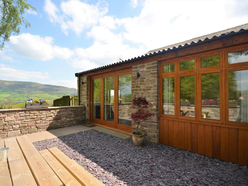 a stone house with a wooden door and windows at 1 Bed in Abergavenny 47884 in Abergavenny