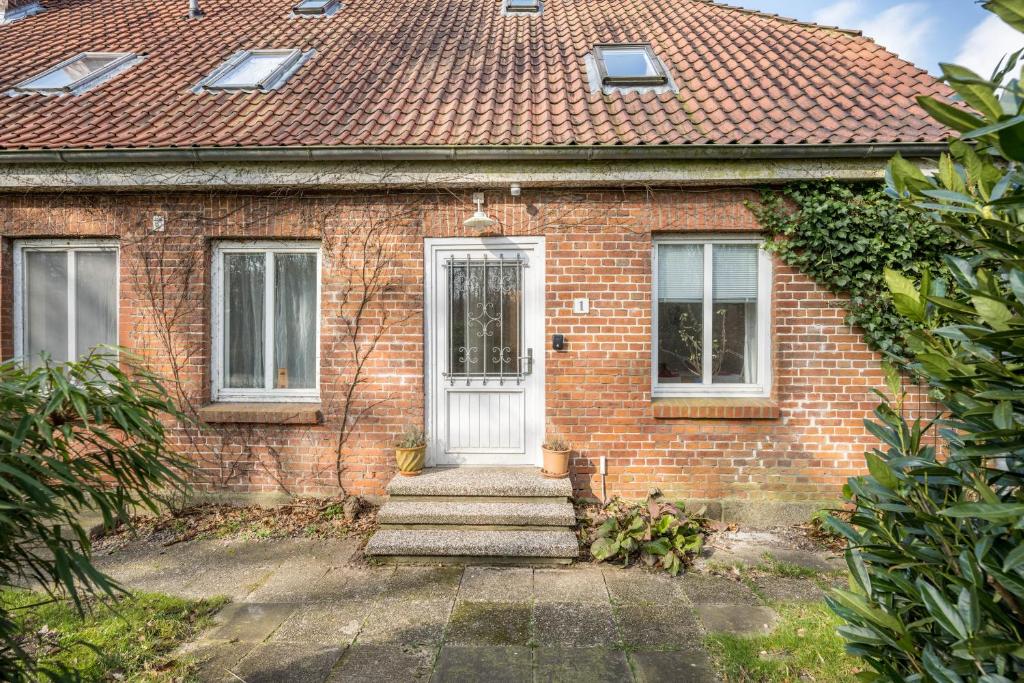 a brick house with a white door and windows at Voßberg Fewo 1 in Grömitz