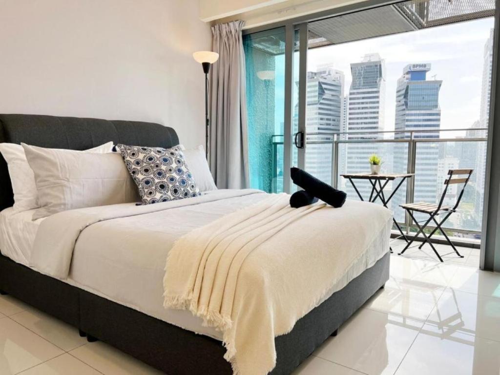 a bedroom with a large bed and a balcony at Mercu Summer Suites Kuala Lumpur Bukit Bintang by Classy in Kuala Lumpur
