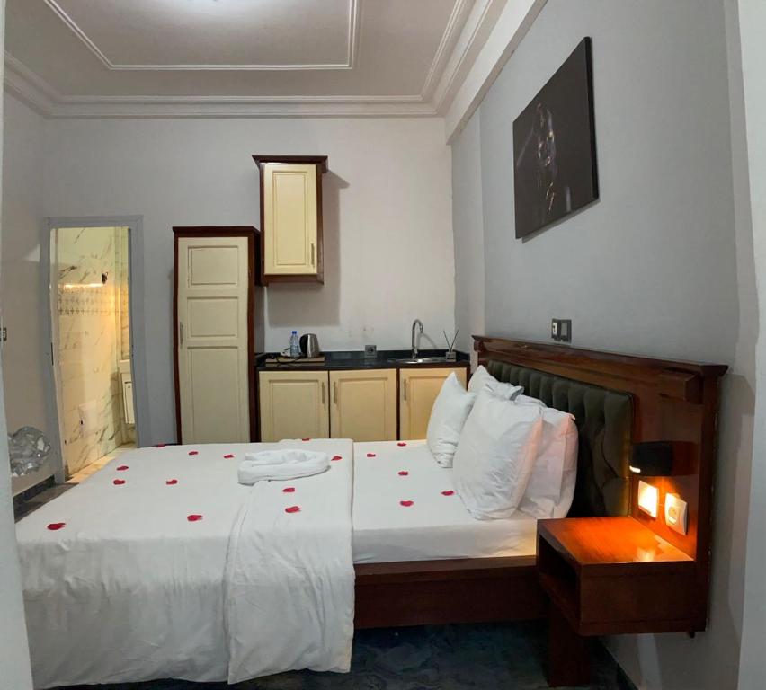 sypialnia z dużym białym łóżkiem z różami w obiekcie SAPHYR GROUP HOTELIER w mieście Duala