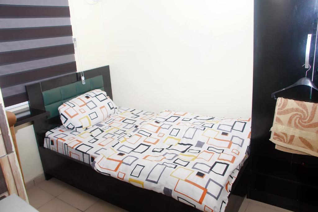 a bed with a quilt on it in a bedroom at Smilley's Place Roffi in Lagos