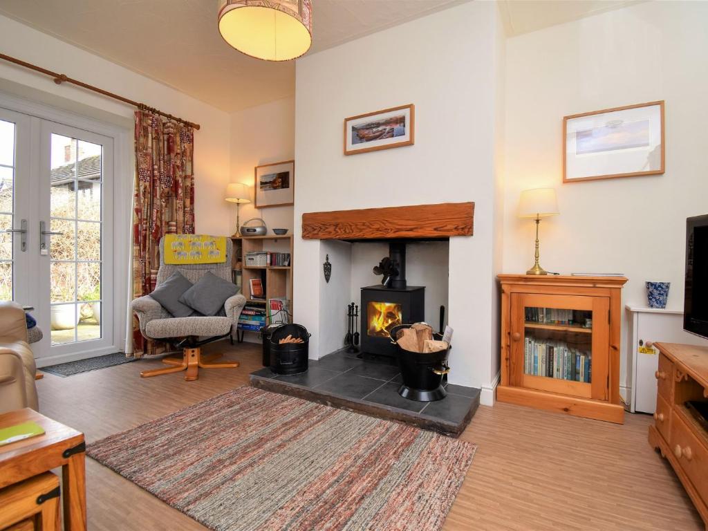a living room with a fireplace and a chair at 1 bed property in Langwathby Cumbria SZ113 in Langwathby