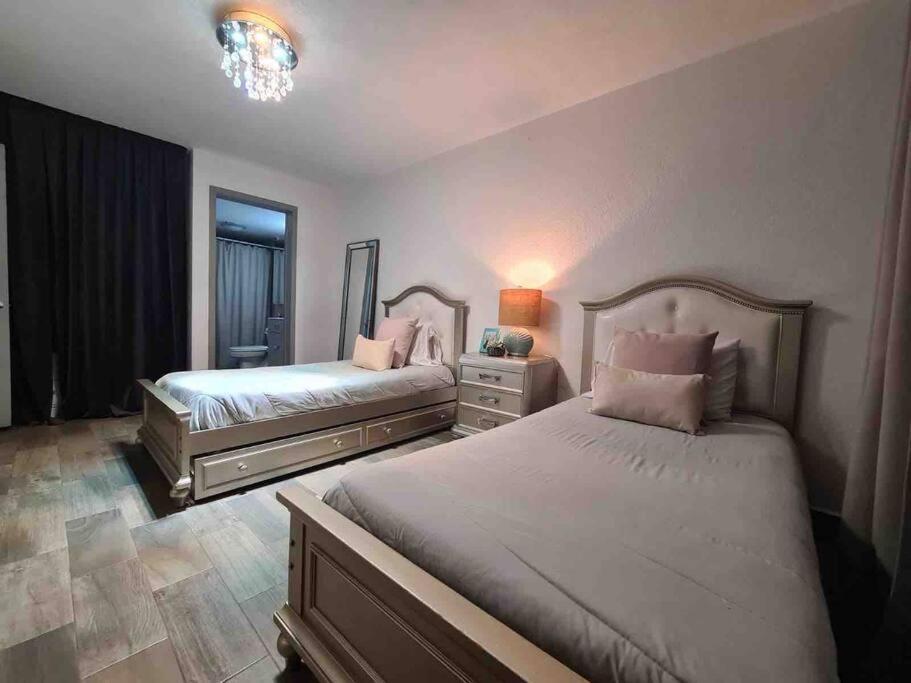 a bedroom with two beds and a mirror at ¡Cómodo departamento con la mejor ubicación! in Tijuana
