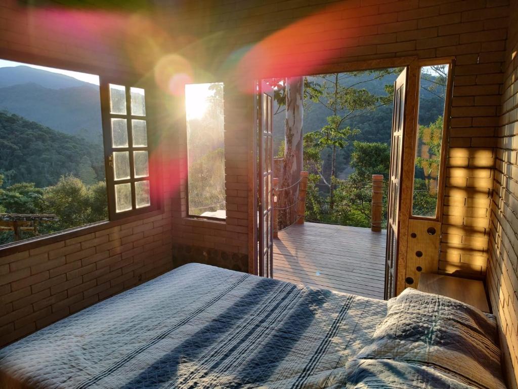 una camera con un letto di fronte a un balcone di Casa Mohini a Teresópolis