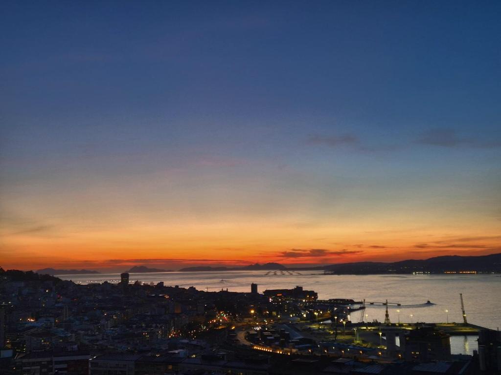 Blick auf den Sonnenuntergang über einer Stadt und dem Wasser in der Unterkunft VistasAragon in Vigo