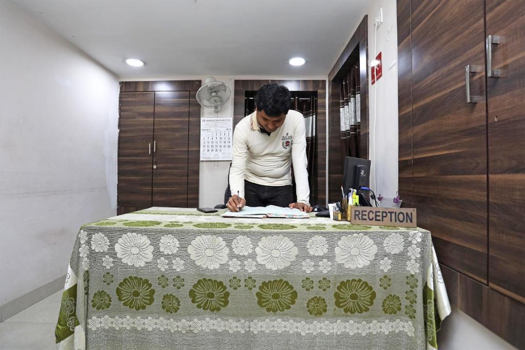 a man standing at a table with a table cloth at Hotel South Fern in Ballygunge