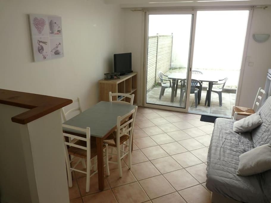 - un salon avec une table et une salle à manger dans l'établissement Petite maison avec jardin, à La Rochelle