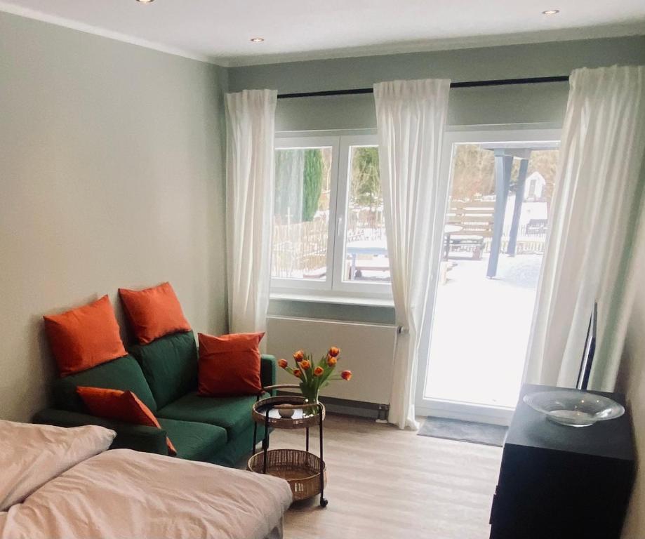 a living room with a green couch and a window at Little Lopsi in Detmold