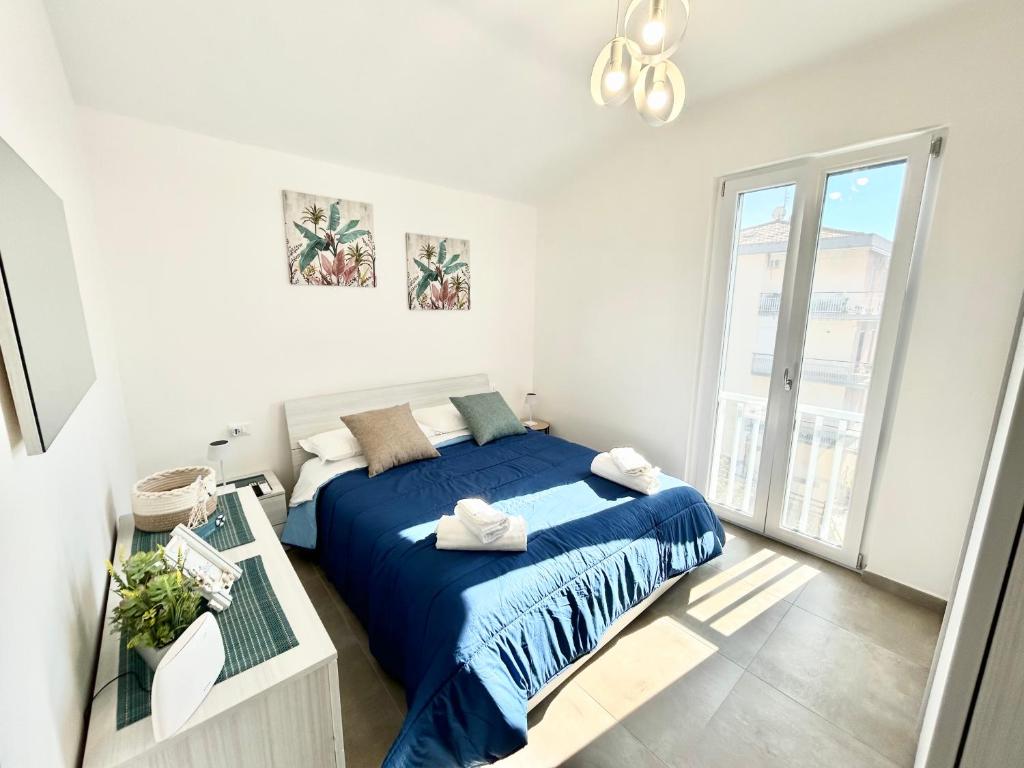 ein Schlafzimmer mit einem blauen Bett und einem Fenster in der Unterkunft Dolce Vita Sperlonga in Sperlonga