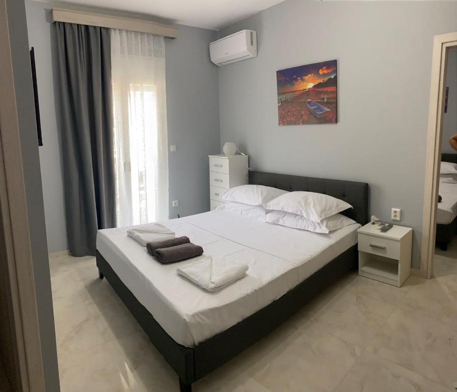 een slaapkamer met een groot bed met witte lakens en kussens bij Umbrella Apartment in Perea